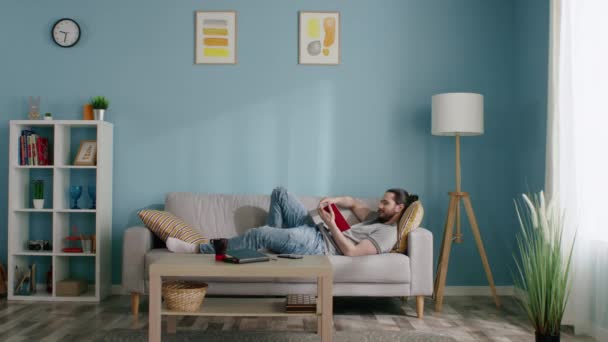 Young Man Is Relaxing on Sofa — Stok Video