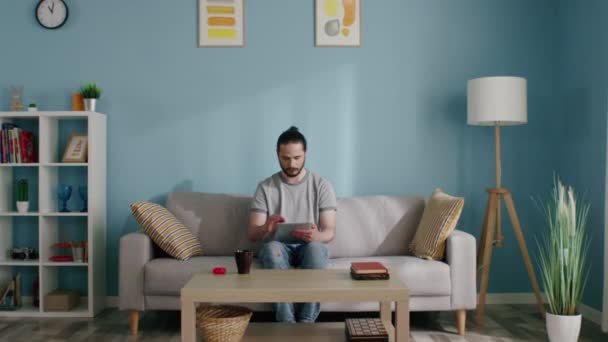 Homem usa computador tablet ficar em casa — Vídeo de Stock