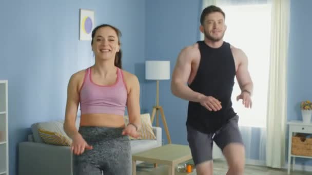 Hombre y mujer jóvenes practican ejercicio cardiovascular en casa — Vídeo de stock