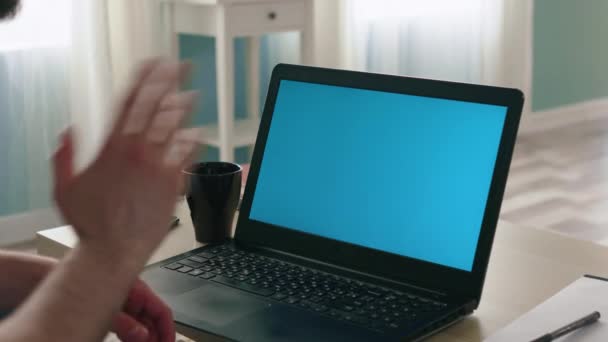 Человек машет привет ноутбуку с зеленым экраном — стоковое видео