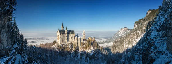 霧の朝、ババリア、ドイツのノイシュヴァンシュタイン城の日当たりの良いパノラマ ビュー. — ストック写真