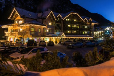 Val di Fassa, Trentino-Alto-Adige bölgesi, İtalya Campitello için ışıklı otelin gün batımı görünümü.
