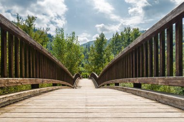 Bulutlu görünümünü Castelfollit de la Roca, La Garrotxa Eyaleti, Catalonia, İspanya yakınındaki ahşap köprü.