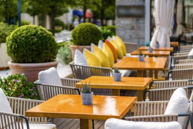 Beautiful and cozy street cafe on the background of luxury yacht
