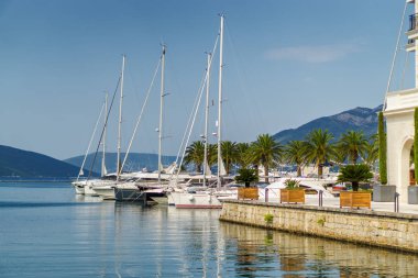 Beautiful and cozy street cafe on the background of luxury yacht