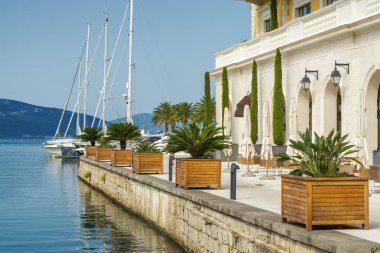 Beautiful and cozy street cafe on the background of luxury yacht