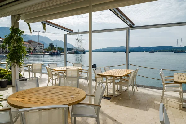Krásná a útulná pouliční kavárna na pozadí luxusní jachty — Stock fotografie