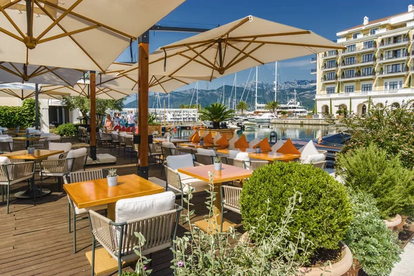 Красивое и уютное уличное кафе на фоне роскошной яхты — стоковое фото