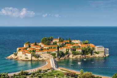 Karadağ 'ın Budva kenti yakınlarındaki Sveti Stefan Adası' nın güneşli sabah manzarası.