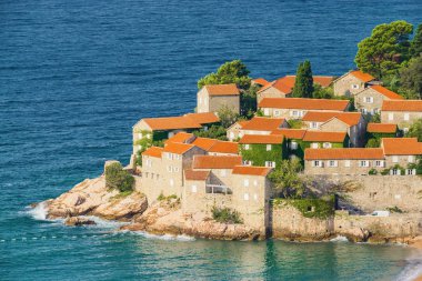 Karadağ 'ın Budva kenti yakınlarındaki Sveti Stefan Adası' nın güneşli sabah manzarası.