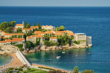 Karadağ 'ın Budva kenti yakınlarındaki Sveti Stefan Adası' nın güneşli sabah manzarası.