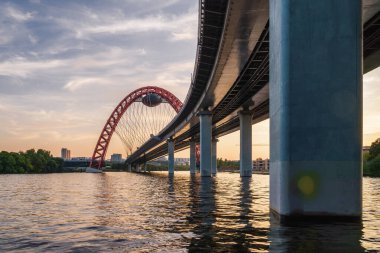 Moskova nehri, Moskova, Rusya Federasyonu üzerindeki büyük kırmızı kemerli Picturesque köprüsünün gün batımı manzarası.