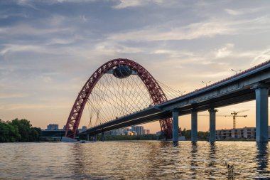 Moskova nehri, Moskova, Rusya Federasyonu üzerindeki büyük kırmızı kemerli Picturesque köprüsünün gün batımı manzarası.
