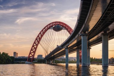 Moskova nehri, Moskova, Rusya Federasyonu üzerindeki büyük kırmızı kemerli Picturesque köprüsünün gün batımı manzarası.
