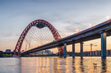 Moskova nehri, Moskova, Rusya Federasyonu üzerindeki büyük kırmızı kemerli Picturesque köprüsünün gün batımı manzarası.