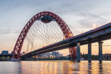 Moskova nehri, Moskova, Rusya Federasyonu üzerindeki büyük kırmızı kemerli Picturesque köprüsünün gün batımı manzarası.