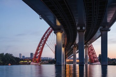 Moskova nehri, Moskova, Rusya Federasyonu üzerindeki büyük kırmızı kemerli Picturesque köprüsünün gün batımı manzarası.