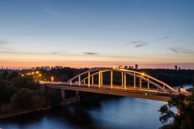Moskova nehri, Moskova, Rusya Federasyonu üzerinde büyük kırmızı kemerli Picturesque köprüsünden gün batımı manzarası.