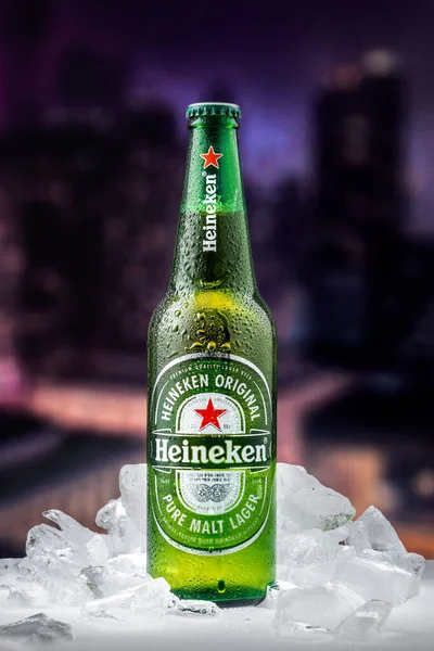 MOSCOW, RUSSIA - 26 Nisan 2020: Bir şişe Heineken birası ve New York şehir merkezindeki günbatımının arka planında buz parçaları. Bu Heineken International 'ın amiral gemisi..