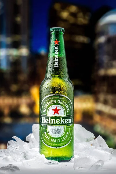 MOSCOW, RUSSIA - 26 Nisan 2020: Bir şişe Heineken birası ve New York şehir merkezindeki günbatımının arka planında buz parçaları. Bu Heineken International 'ın amiral gemisi..