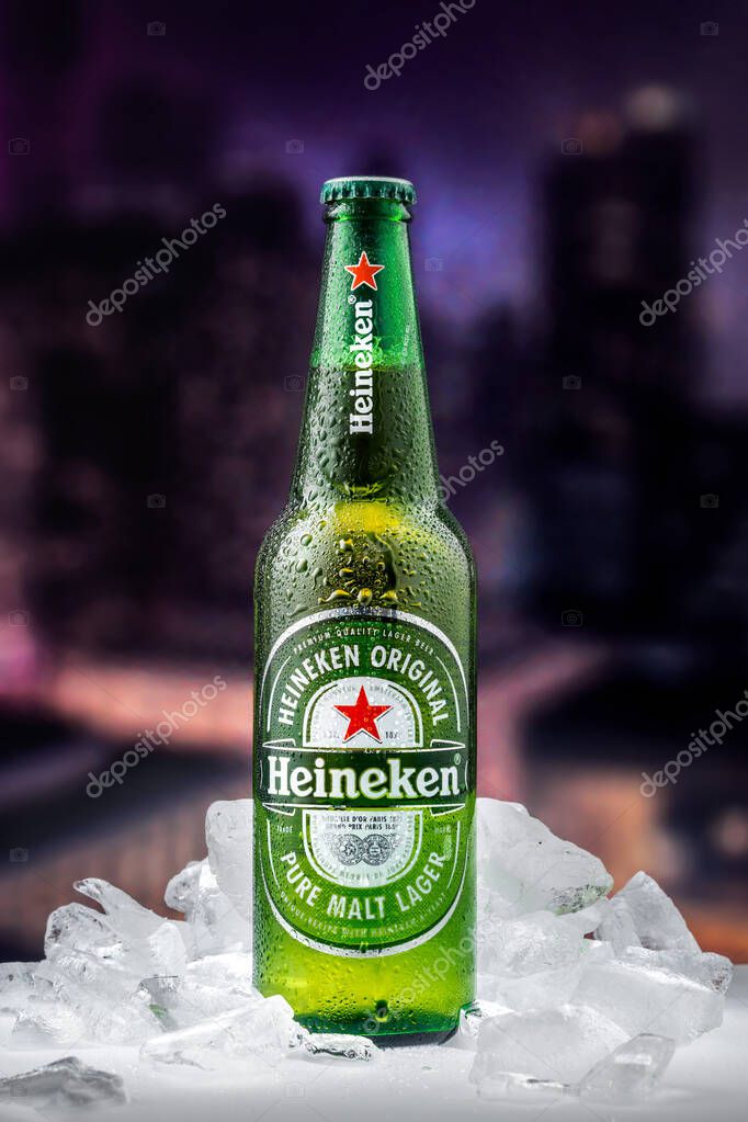 MOSCOW, RUSSIA - APRIL 26, 2020: Bottle of Heineken lager beer with pieces of ice on the background of sunset downtown of New York. This is flagship product of Heineken International.
