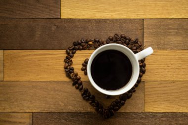 Kahve çekirdekleri ve bir fincan kahvenin ahşap tuğlalar üzerinde kompozisyonu, düz görünüm.