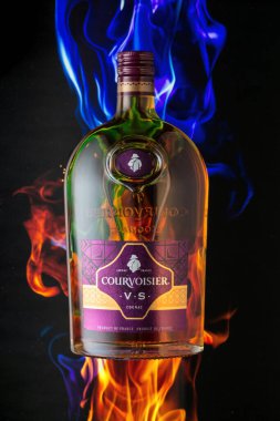 MOSCOW, RUSSIA - 10 Mayıs 2020: yangın arka planında Courvoisier konyak şişesi. Courvoisier dünyadaki en popüler dört konyak markasından biri..
