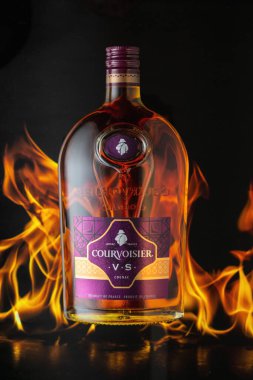 MOSCOW, RUSSIA - 10 Mayıs 2020: yangın arka planında Courvoisier konyak şişesi. Courvoisier dünyadaki en popüler dört konyak markasından biri..