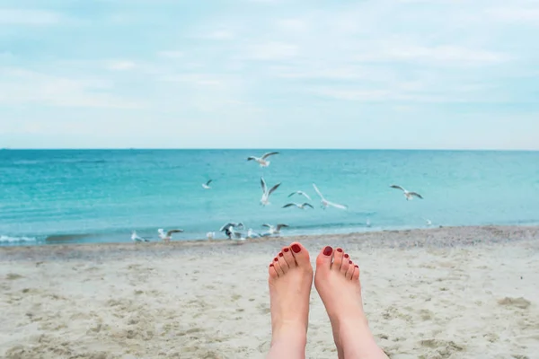 Pieds de femme avec des ongles rouges sur le fond de la mer — Photo