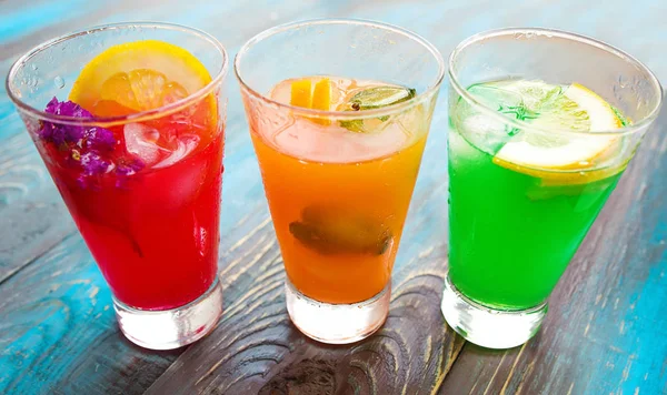 Diferentes tipos de limonadas frescas en vasos sobre fondo de madera — Foto de Stock