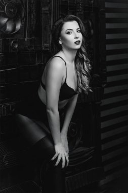 Genç güzel çekici ve sıcak kadın Foto stüdyo tek renkli endüstriyel zemin üzerine siyah iç çamaşırı 