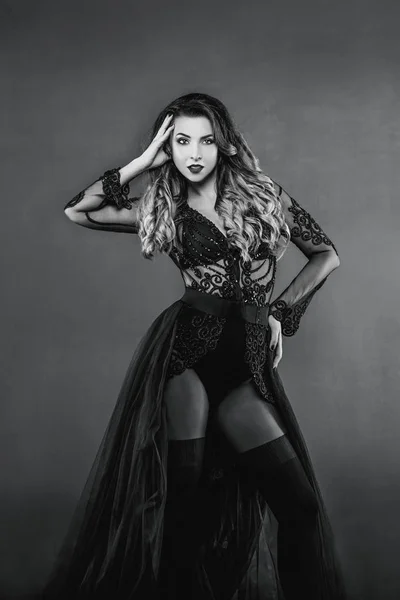 Jeune belle femme aux cheveux longs attrayant et chaud en sous-vêtements noirs sur fond gris en studio photo — Photo