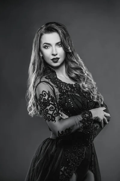 Mladé krásné atraktivní a teplé dlouhé vlasy žena v černém prádle na šedém pozadí ve fotoateliéru — Stock fotografie