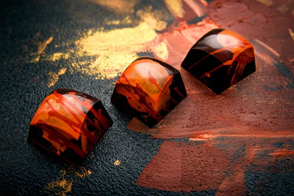 Унікальні шоколадні цукерки ручної роботи на абстрактному фоні — стокове фото