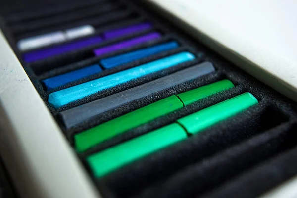 Stukken van kleurrijke pastel krijtjes in het vak — Stockfoto