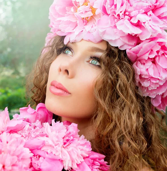 Retrato de mujer rizada hermosa joven en la corona de peonía al aire libre sobre fondo verde —  Fotos de Stock