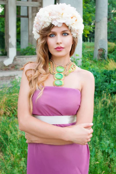 Portrait de jeune belle femme bouclée dans la couronne de pivoine en plein air sur fond vert — Photo