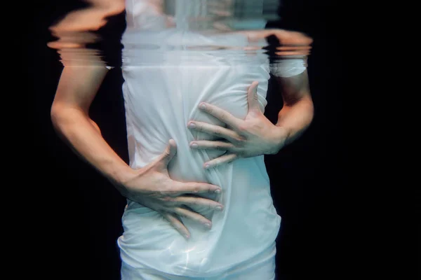 Tanzende Hände unter Wasser auf schwarzem Hintergrund im Schwimmbad — Stockfoto