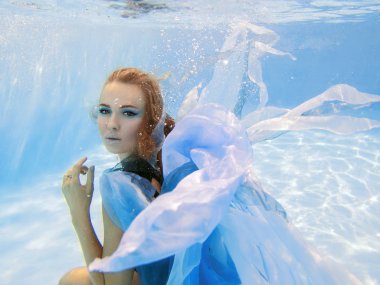 Mavi elbiseli güzel genç kadın portresi sualtı moda 