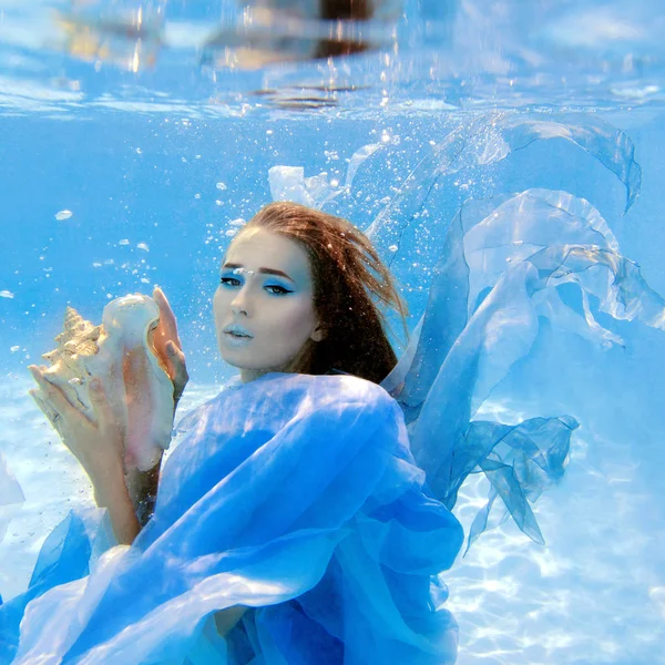 Onderwater mode portret van mooie jonge vrouw in blauwe jurk — Stockfoto