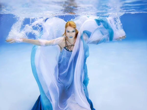 Onderwater mode portret van mooie blonde jonge vrouw in blauwe jurk — Stockfoto