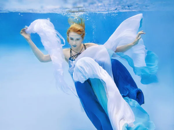Onderwater mode portret van mooie blonde jonge vrouw in blauwe jurk — Stockfoto