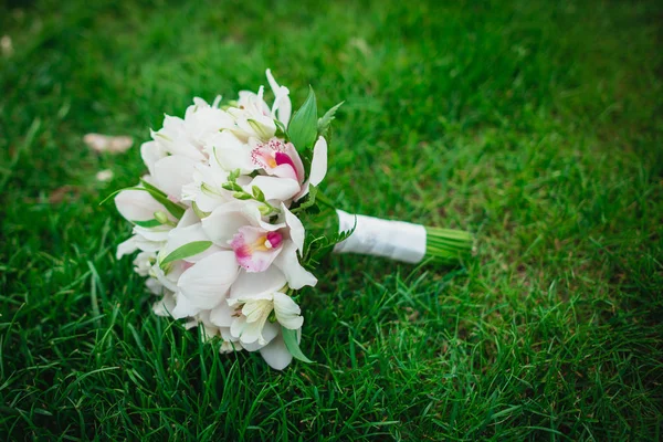 Hermoso increíble orquídeas blancas flores ramo de boda en la hierba verde —  Fotos de Stock