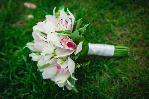 Hermoso increíble orquídeas blancas flores ramo de boda en la hierba verde —  Fotos de Stock