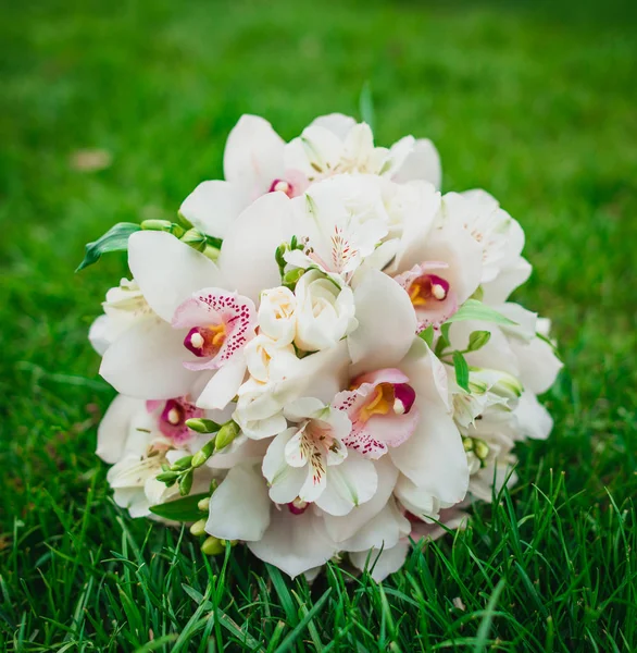 Krásné úžasné bílé orchideje květiny svatební kytice na zelené trávě — Stock fotografie