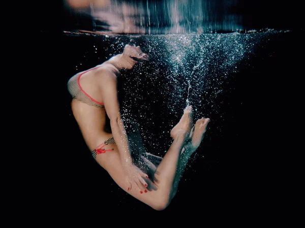 Onderwater portret van jonge aantrekkelijke mooie vrouw (gratis duiker) tegen de donkere achtergrond — Stockfoto