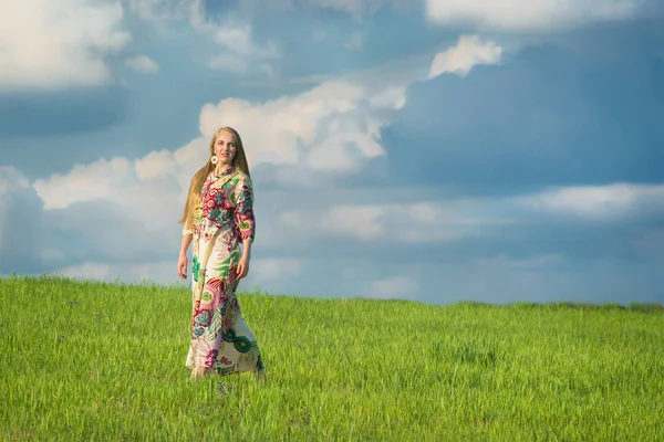 Молодий красивою дівчиною з давно світле волосся в зеленому полі у відкритий етнічні села Пирогово, Київ — стокове фото