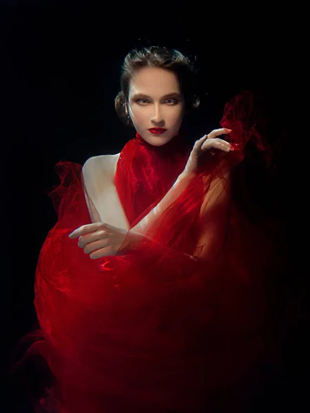 Undervatten porträtt ot ung vacker flicka med make up i röd snygg klänning i poolen — Stockfoto