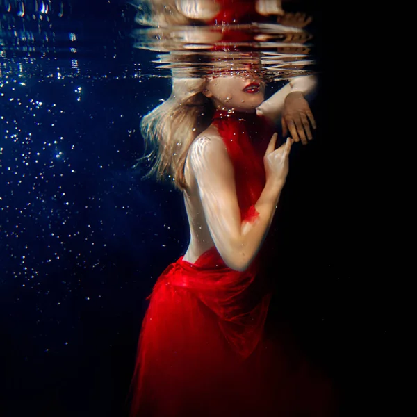 Ritratto subacqueo ot giovane bella ragazza con make up in abito rosso elegante in piscina — Foto Stock