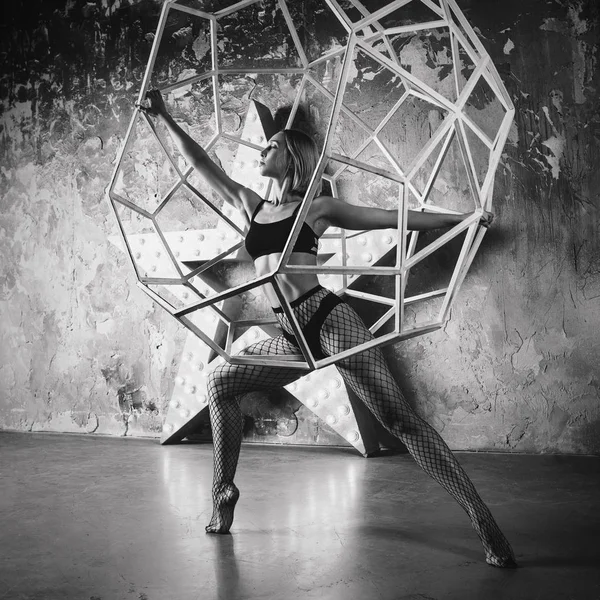 portrait of beautiful attractive blonde woman dancer with huge star on the background  in the loft dance studio